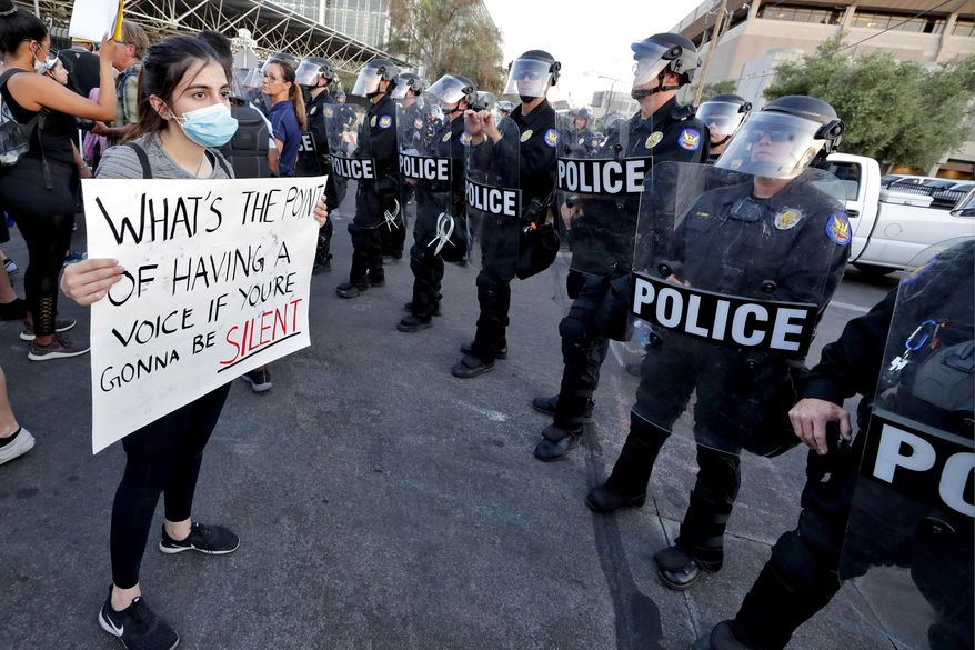 Protesters confront Phoenix Police officers Tuesday, June 2, 2020, in Phoenix during demonstrations over the death of George Floyd, a black man who died after being restrained by Minneapolis police officers on May 25. (AP Photo/Matt York)