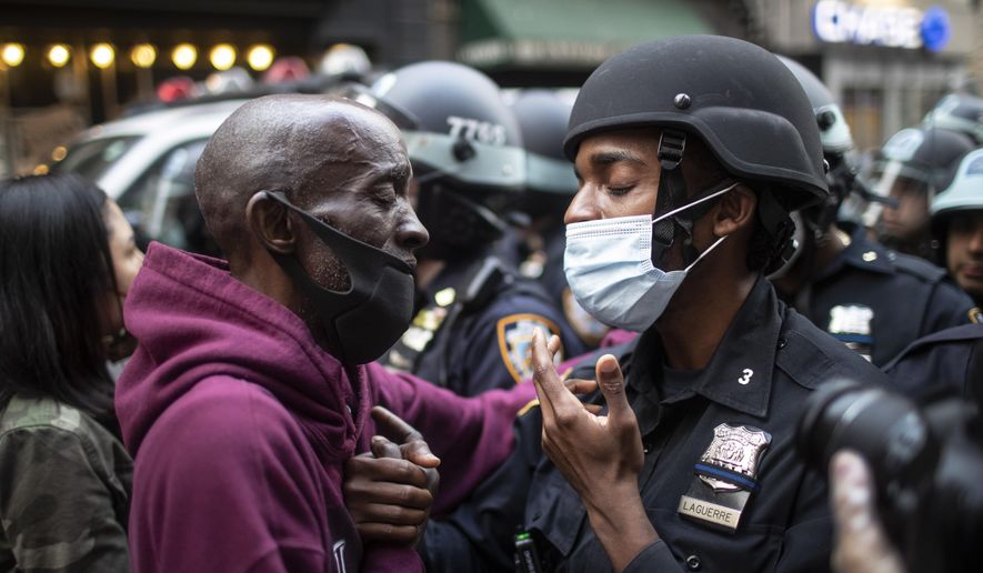 A protester and a police officer shake hands in the middle of a standoff during a solidarity rally calling for justice over the death of George Floyd Tuesday, June 2, 2020, in New York. Floyd died after being restrained by Minneapolis police officers on May 25. (AP Photo/Wong Maye-E)