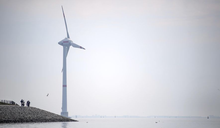 Cyclists ride along the dyke in Emden, Germany, Wednesday, June 3, 2020. The German government wants to increase offshore wind power capacity five-fold by 2040 as part of its plan to wean the country off fossil fuels. Cabinet on Wednesday agreed a bill that would set a goal of 40 Gigawatts of installed offshore wind power capacity in 20 years, from about 7.5 Gigawatts at present. It also raised the target for 2030 from 15 Gigawatts to 20. (Sina Schuldt/dpa via AP)