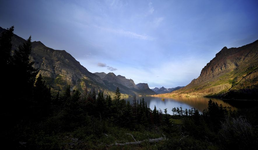 FILE - This Aug. 14, 2019, file photo shows a view of the iconic Wild Goose Island from Going-to-the-Sun Road on St. Mary Lake at sunrise in Glacier National Park. The park will start a limited reopening for visitors on Monday, June 8, 2020, with the opening of the west entrance at West Glacier. The east entrances to the park will remain closed because the neighboring Blackfeet Indian Reservation has coronavirus restrictions in place through June 30. (Brenda Ahearn//The Daily Inter Lake via AP, FIle)