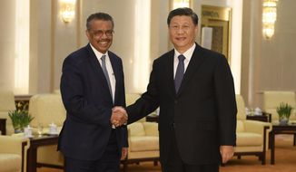 FILE - In this Jan. 28, 2020, file photo, Tedros Adhanom Ghebreyesus, director general of the World Health Organization, left, shakes hands with Chinese President Xi Jinping before a meeting at the Great Hall of the People in Beijing. Throughout January, the World Health Organization publicly praised China for what it called a speedy response to the new coronavirus. It repeatedly thanked the Chinese government for sharing the genetic map of the virus “immediately” and said its work and commitment to transparency were “very impressive, and beyond words.” But behind the scenes, there were significant delays by China and considerable frustration among WHO officials over the lack of outbreak data, The Associated Press has found. (Naohiko Hatta/Pool Photo via AP, File)