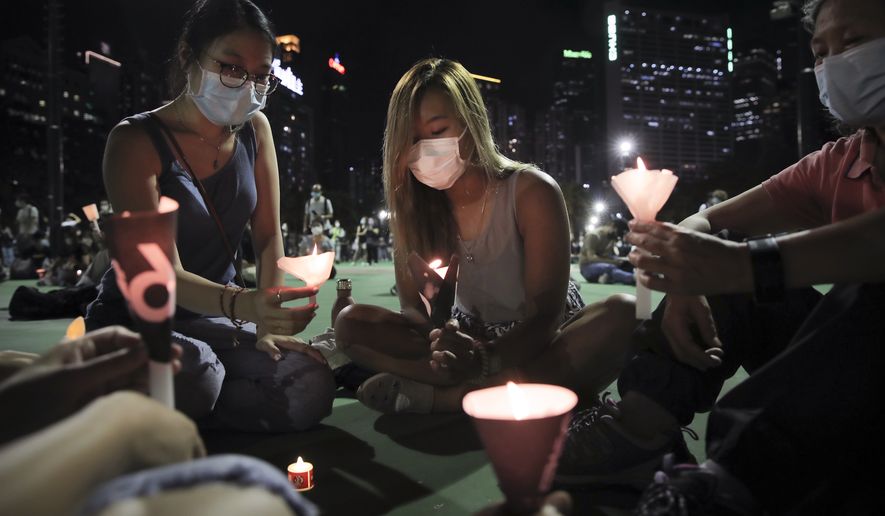 Participants holds candles during a vigil for the victims of the 1989 Tiananmen Square Massacre at Victoria Park in Causeway Bay, Hong Kong, Thursday, June 4, 2020, despite applications for it being officially denied. China is tightening controls over dissidents while pro-democracy activists in Hong Kong and elsewhere try to mark the 31st anniversary of the crushing of the pro-democracy movement in Beijing&#39;s Tiananmen Square. (AP Photo/Kin Cheung)