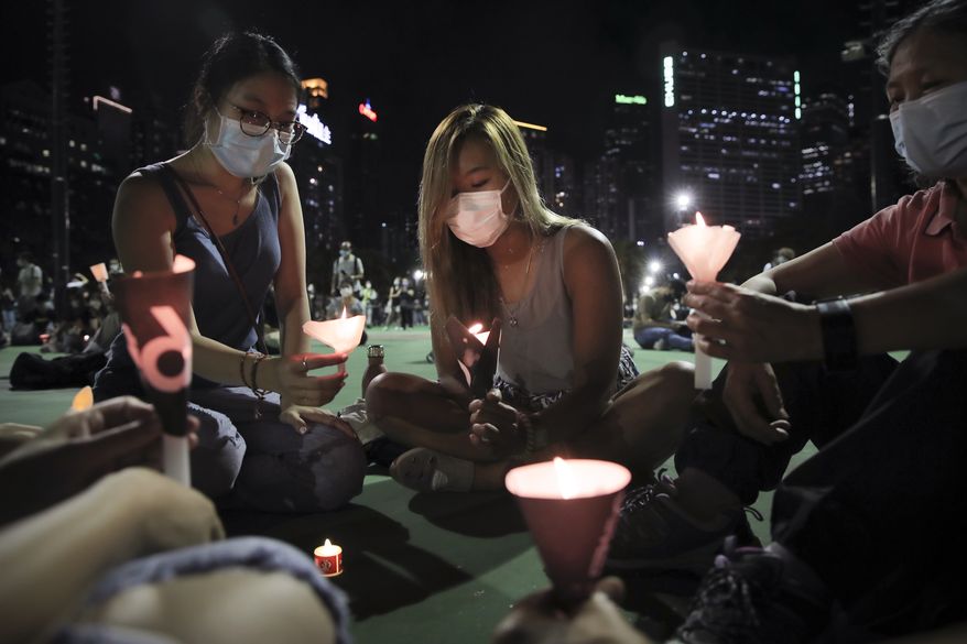 Participants holds candles during a vigil for the victims of the 1989 Tiananmen Square Massacre at Victoria Park in Causeway Bay, Hong Kong, Thursday, June 4, 2020, despite applications for it being officially denied. China is tightening controls over dissidents while pro-democracy activists in Hong Kong and elsewhere try to mark the 31st anniversary of the crushing of the pro-democracy movement in Beijing&#39;s Tiananmen Square. (AP Photo/Kin Cheung)