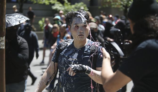 In this June 29, 2019, photo, Andy Ngo, a conservative writer, is seen after being attacked by a group of left-wing protesters at a demonstration in Portland, Ore. Ngo has filed a lawsuit against purported elements of the nebulous far-left-leaning militant groups collectively known as antifa on Thursday, June 4 2020. Ngo has drawn attention to antifa for years and says he was targeted and suffered brain injuries when he was assaulted while covering protests in Portland a year ago. The suit seeks $900,000 in damages, claiming assault, battery and intentional infliction of emotional distress, and an injunction barring the group from further harassment, accusing Rose City Antifa of “pattern of racketeering activities” among other legal claims. (Dave Killen/The Oregonian via AP)