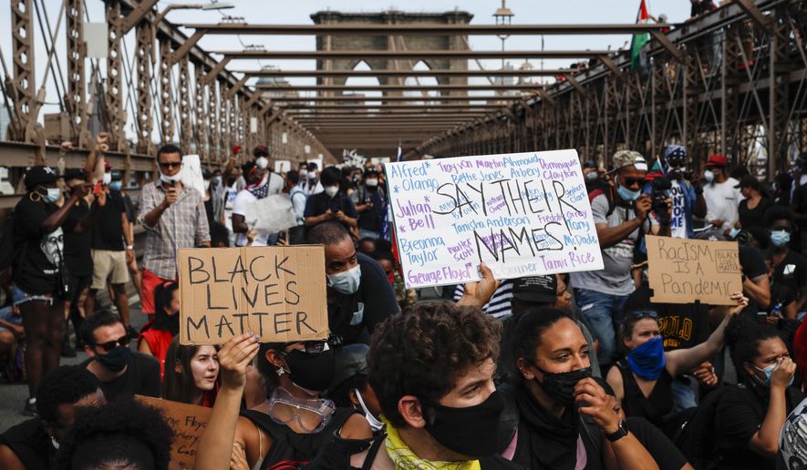 Protesters take a knee before continuing their march on the Brooklyn Bridge after attending a memorial service for George Floyd, on Thursday, June 4, 2020, in the Brooklyn borough of New York. Floyd, an African American man, died on May 25 after a white Minneapolis police officer pressed a knee into his neck for several minutes even after he stopped moving and pleading for air. (AP Photo/John Minchillo)
