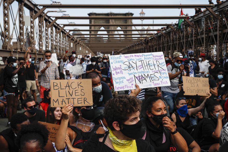 Protesters take a knee before continuing their march on the Brooklyn Bridge after attending a memorial service for George Floyd, on Thursday, June 4, 2020, in the Brooklyn borough of New York. Floyd, an African American man, died on May 25 after a white Minneapolis police officer pressed a knee into his neck for several minutes even after he stopped moving and pleading for air. (AP Photo/John Minchillo)