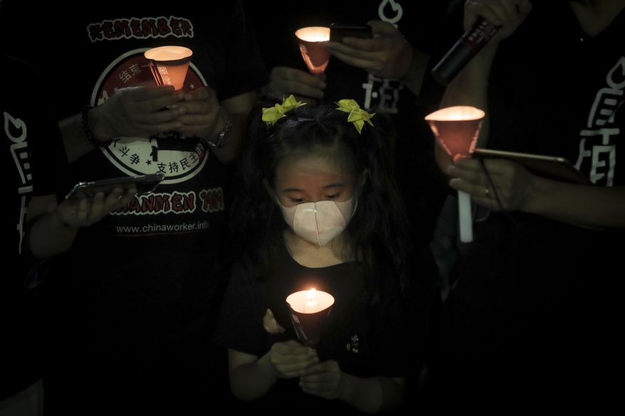 Participants holds candles during a vigil for the victims of the 1989 Tiananmen Square Massacre at Victoria Park in Causeway Bay, Hong Kong, Thursday, June 4, 2020, despite applications for it being officially denied. China is tightening controls over dissidents while pro-democracy activists in Hong Kong and elsewhere try to mark the 31st anniversary of the crushing of the pro-democracy movement in Beijing's Tiananmen Square. (AP Photo/Kin Cheung)