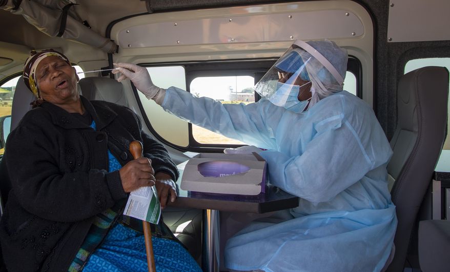 An elderly woman reacts as a heath worker collects a sample for coronavirus testing during the screening and testing campaign aimed to combat the spread of COVID-19 at Sphamandla informal settlement in Katlehong, south of Johannesburg, South Africa, Friday, May 22, 2020. (AP Photo/Themba Hadebe)
