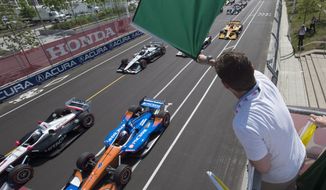 FILE - In this July 15, 2018, file photo, Jason Priestley waves the green flag to start an IndyCar auto race in Toronto. The stars of IndyCar were in Florida preparing to start their season when the coronavirus pandemic slammed the brakes on those plans 48 hours before the green flag.  Almost three months later, the series is finally set to go racing.  The 2020 season will open Saturday night, June 6, 2020, at Texas Motor Speedway in NBC&#39;s first ever primetime IndyCar race. (Frank Gunn/The Canadian Press via AP, File)