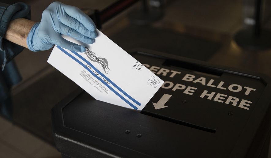 A voter cast her mail-in ballot at in a drop box in West Chester, Pa., prior to the primary election, Thursday, May 28, 2020. (AP Photo/Matt Rourke)