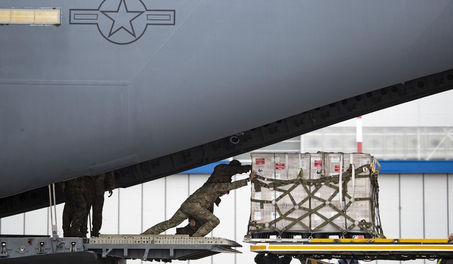 U.S. soldiers unload medical aid from the United States, including ventilators as a donation to help the country tackle the coronavirus outbreak, after a U.S. airforce plane landed at Vnukovo International Airport outside in Moscow on Thursday, June 4, 2020. (AP Photo/Pavel Golovkin) **FILE**