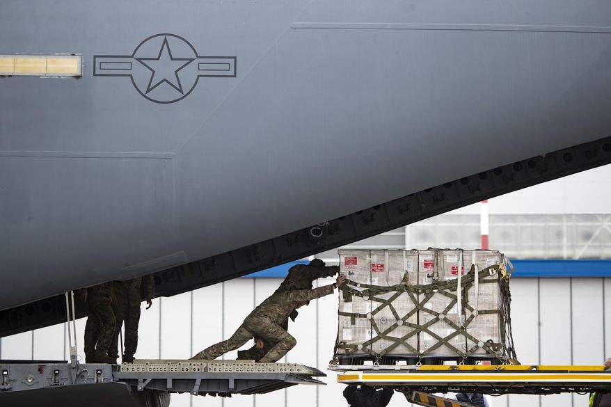 U.S. soldiers unload medical aid from the United States, including ventilators as a donation to help the country tackle the coronavirus outbreak, after a U.S. airforce plane landed at Vnukovo International Airport outside in Moscow on Thursday, June 4, 2020. (AP Photo/Pavel Golovkin) **FILE**