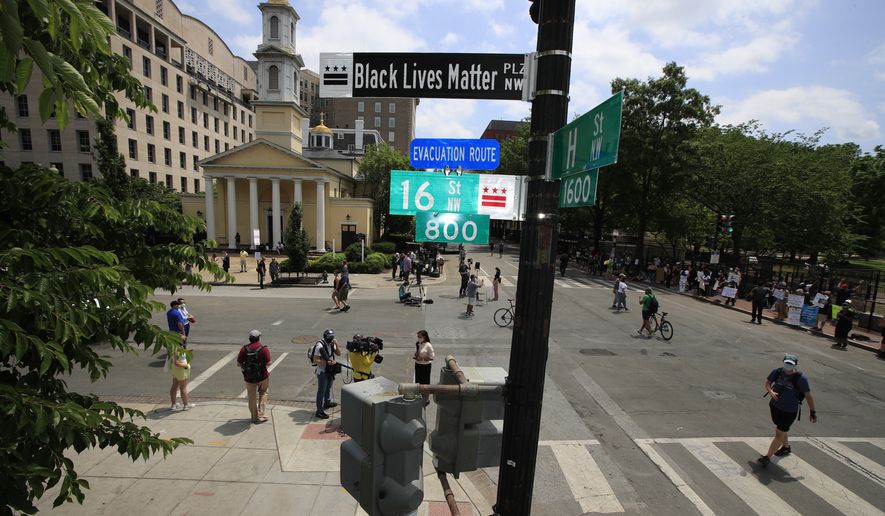 With St. John&#39;s Church in the background, people walk under a new street sign on Friday, June 5, 2020, in Washington. &quot;The section of 16th street in front of the White House is now officially &#39;Black Lives Matter Plaza,&#39;&quot; District of Columbia Mayor Muriel Bowser tweeted. The black and white sign was put up to mark the change. (AP Photo/Manuel Balce Ceneta)