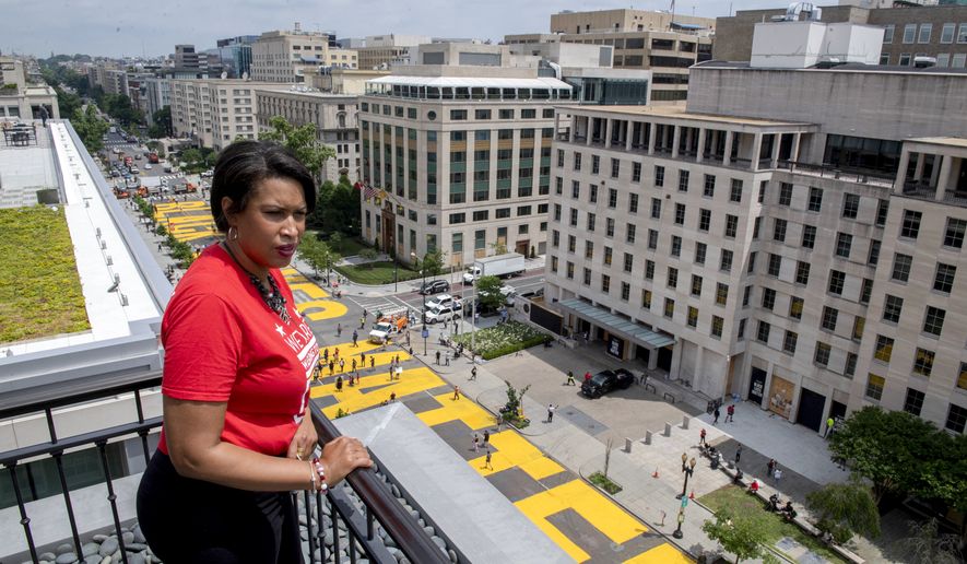 In this image provided by the Executive Office of the Mayor, District of Columbia Mayor Muriel Bowser stands on the rooftop of the Hay Adams Hotel near the White House and looks out at the words &#39;Black Lives Matter&#39; that have been painted in bright yellow letters on the street by city workers and activists, Friday, June 5, 2020, in Washington. (Executive Office of the Mayor/Khalid Naji-Allah via AP) ** FILE **