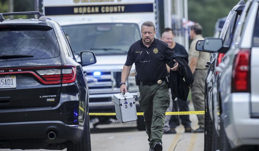 A Morgan County, Ala. investigator works at the scene, Friday, June 5, 2020, in Valhermoso Springs, Ala., where numerous people were found fatally shot. Deputies responding to a call about a shooting in Alabama found seven people dead inside a home that had been set afire early Friday, authorities said. (Jeronimo Nisa/The Decatur Daily via AP)