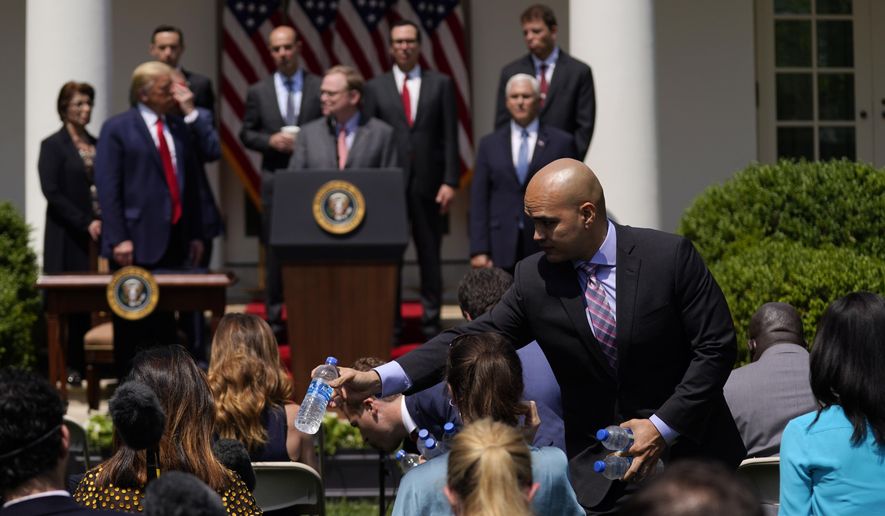 Water is handed out to members of the press as President Donald Trump holds a news conference in the Rose Garden of the White House, Friday, June 5, 2020, in Washington. (AP Photo/Evan Vucci)