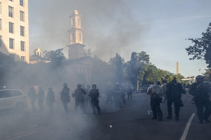 In this June 1, 2020, file photo police move demonstrators away from St. John's Church across Lafayette Park from the White House, as they gather to protest the death of George Floyd in Washington. Floyd died after being restrained by Minneapolis police officers. (AP Photo/Alex Brandon, File)