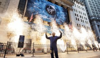 FILE - In this Monday, Oct. 28, 2019 file photo, Sir Richard Branson, founder of Virgin Galactic, poses for a photo outside the New York Stock Exchange as fireworks are exploded before his company&#39;s IPO. In 2020, NASA Administrator Jim Bridenstine said space is currently a $400 billion market, including satellites. Opening up spaceflight to paying customers, he said, could expand the market to $1 trillion. (AP Photo/Richard Drew)