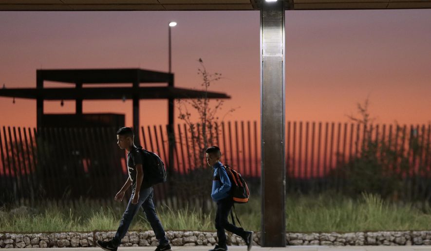In this May 27, 2020 photo, Columbus Elementary School students walk alone across the the new port of entry between Columbus and Palomas as the sun rises behind them. A new Columbus port of entry, designed by Corpus Christi, Texas-based Richter Architects, has earned recognition from the American Institute of Architects and Texas Society of Architects. (Mark Lambie/The El Paso Times via AP)