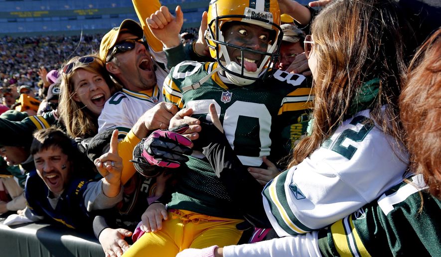 FILE - In this Oct. 28, 2012, file photo, Green Bay Packers wide receiver Donald Driver celebrates a touchdown after doing a Lambeau Leap during the second half of an NFL football game against the Jacksonville Jaguars, in Green Bay, Wisc. As lock-downs are lifted, restrictions on social gatherings eased and life begins to resemble some sense, sports are finally starting to emerge from the coronavirus pandemic. Many sports business experts believe those hardy fans will be the first to return. (AP Photo/Mike Roemer, File)