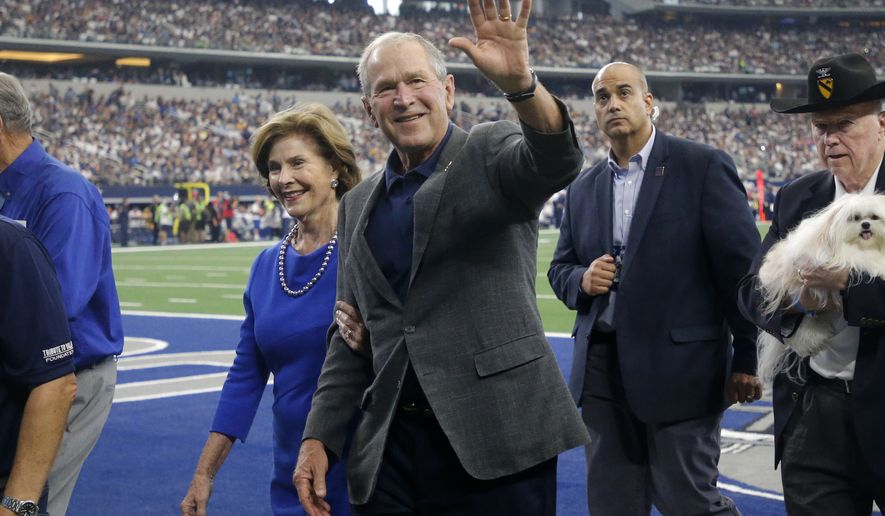 Former President George W. Bush and wife Laura walk off the field after participating in a ceremony with Medal of Honor recipients in the first half of an NFL football game between the Green Bay Packers and Dallas Cowboys in Arlington, Texas, Sunday, Oct. 6, 2019. (AP Photo/Michael Ainsworth)