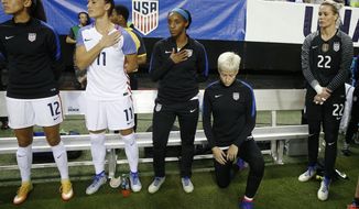 In this Sept. 18, 2016, file photo, United States&#39; Megan Rapinoe, right, kneels next to teammates Christen Press (12), Ali Krieger (11), Crystal Dunn (16) and Ashlyn Harris (22) as the national anthem is played before the team&#39;s exhibition soccer match against the Netherlands in Atlanta. The U.S. women&#39;s national team wants the U.S. Soccer Federation to repeal the anthem policy it instituted after Rapinoe started kneeling during the national anthem. The U.S. women&#39;s team also wants the federation to state publicly that the policy was wrong and issue an apology to the team&#39;s black players and supporters. (AP Photo/John Bazemore, File)  **FiLE**