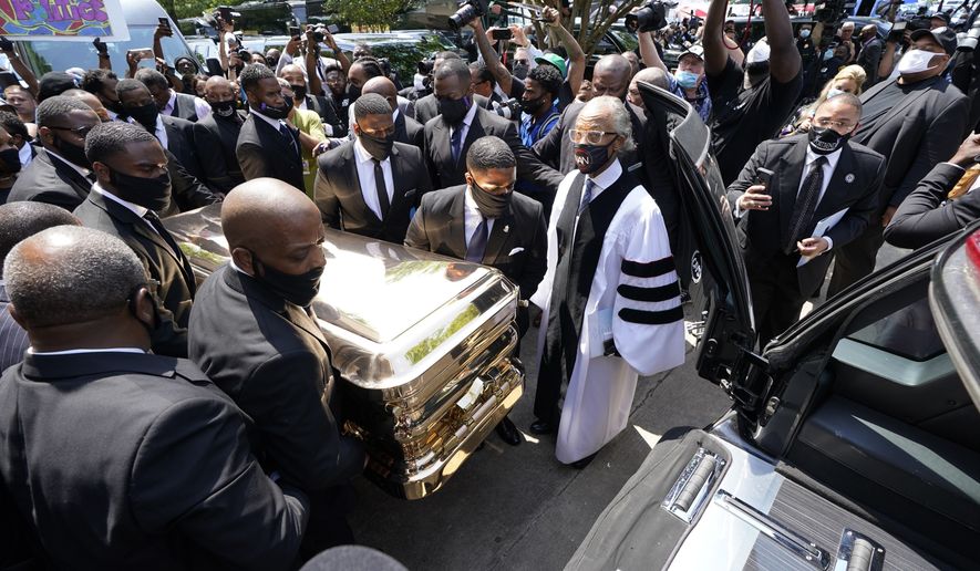 The funeral home team pushes the casket of George Floyd into the hearse as the Rev. Al Sharpton, right, looks on after the funeral service for George Floyd at The Fountain of Praise church Tuesday, June 9, 2020, in Houston. (AP Photo/David J. Phillip, Pool)
