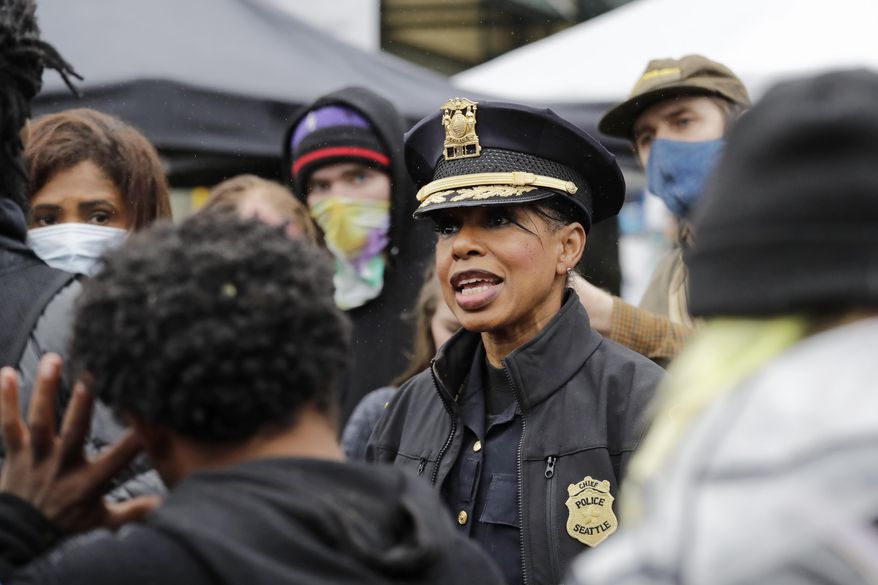 Seattle Police Chief Carmen Best talks with activists near a plywood-covered and closed Seattle police precinct Tuesday, June 9, 2020, in Seattle, following protests over the death of George Floyd, a black man who was in police custody in Minneapolis. (AP Photo/Elaine Thompson)
