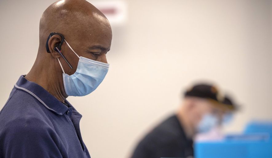 FILE - In this May 18, 2020, file photo, Charles McClendon, of Snellville, votes in Georgia's primary election at the Gwinnett County Voter Registration and Elections Office in Lawrenceville, Ga. Early voting began that day. (Alyssa Pointer/Atlanta Journal-Constitution via AP, File)