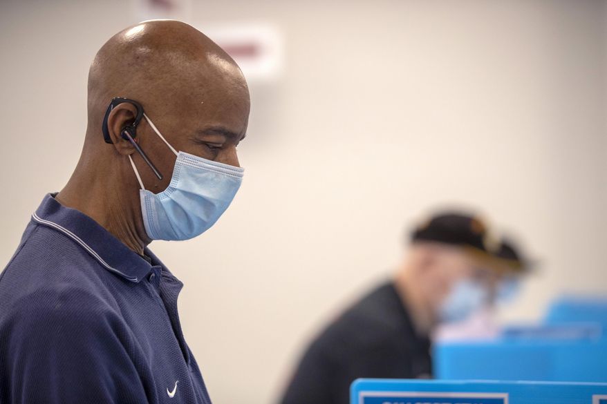FILE - In this May 18, 2020, file photo, Charles McClendon, of Snellville, votes in Georgia's primary election at the Gwinnett County Voter Registration and Elections Office in Lawrenceville, Ga. Early voting began that day. (Alyssa Pointer/Atlanta Journal-Constitution via AP, File)