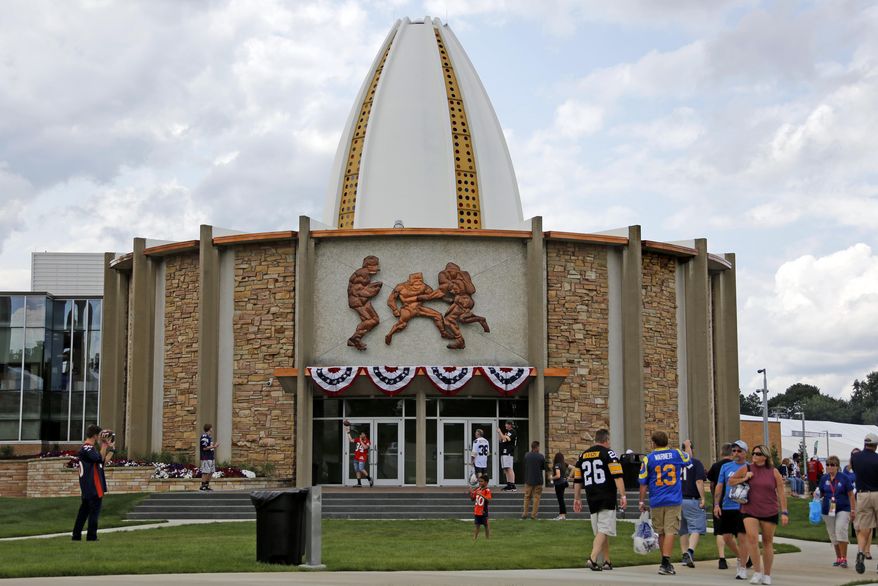 In this Aug. 5, 2017, file photo, football fans toss footballs on the lawn outside the Pro Football Hall of Fame in Canton, Ohio. The Pro Football Hall of Fame will reopen Wednesday, June 10, 2020, after nearly a three-month hiatus due to the coronavirus pandemic. (AP Photo/Gene J. Puskar, File) **FILE**