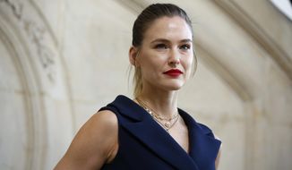 FILE - In this Feb. 26, 2019 file photo, Israeli top model Bar  Refaeli poses for photographers at the Dior ready to wear Fall-Winter 2019-2020 collection, in Paris. Refaeli has signed a plea bargain agreement with authorities to settle a long-standing tax evasion case against her and her family. The deal will require Refaeli to serve nine months of community service while her mother will be sent to prison for 16 months. The two are also ordered to pay a $1.5 million fine on top of millions of back taxes owed to the state. (AP Photo/Thibault Camus, File)