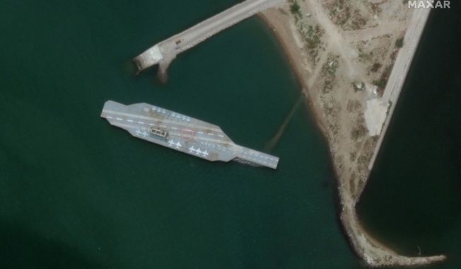 In this Sunday, June 7, 2020 satellite photo provided by Maxar Technologies, a fake aircraft carrier is seen off the coast of Bandar Abbas, Iran. As tensions remain high between Iran and the U.S., the Islamic Republic appears to have constructed a new mockup of an aircraft carrier off its southern coast for potential live-fire drills. The faux foe, seen in satellite photographs obtained by The Associated Press, resembles the Nimitz-class carriers that the U.S. Navy routinely sails into the Persian Gulf from the Strait of Hormuz, its narrow mouth that sees 20% of all the world&#x27;s oil pass through it. (Satellite image ©2020 Maxar Technologies via AP)