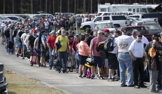 In this Saturday, May 23, 2020 photo, hundreds of race fans wait in line to purchase tickets at the Ace Speedway on in the rural Alamance County community of Altamahaw near Elon, N.C. North Carolina Gov. Roy Cooper’s administration has ordered closed a small stock-car track that’s allowed large crowds to gather repeatedly for weekend races well above COVID-19 limits for mass gatherings. Cooper’s health secretary says Ace Speedway in Alamance County is an “imminent hazard” for the virus&#39; spread and can&#39;t reopen unless it creates a safety plan to keep fans away. (Robert Willett/The News &amp;amp; Observer via AP)  **FILE**