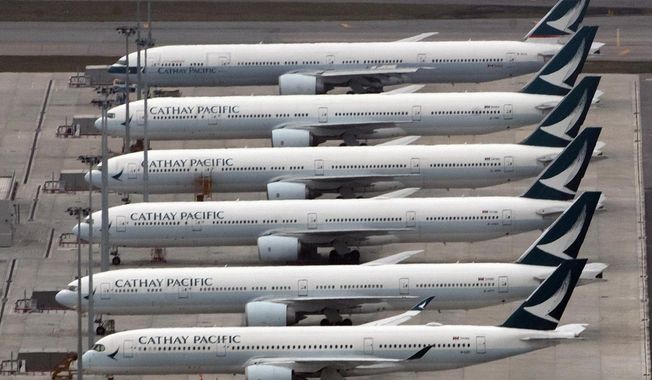 FILE - In this March 6, 2020, file photo, Cathay Pacific Airways aircraft line up on the tarmac at the Hong Kong International Airport. Financially battered Hong Kong airline Cathay Pacific Airways says it is proposing the government help fund a $5 billion recapitalization plan to help it recover from the coronavirus pandemic. (AP Photo/Kin Cheung)