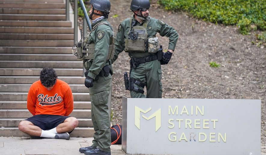 Texas Department of Public Safety troopers hold a man in custody at the corner of Commerce and and Elm streets in Dallas as law enforcement begins enforcing a 7:00 p.m. curfew, Sunday, May 31, 2020, in Dallas. During protests in Dallas on May 31, someone gained access to the police department’s unencrypted radio frequency and disrupted officers’ communications by playing music over their radios, according to a June 1 intelligence assessment from the U.S. Department of Homeland Security. (Smiley N. Pool/The Dallas Morning News via AP)