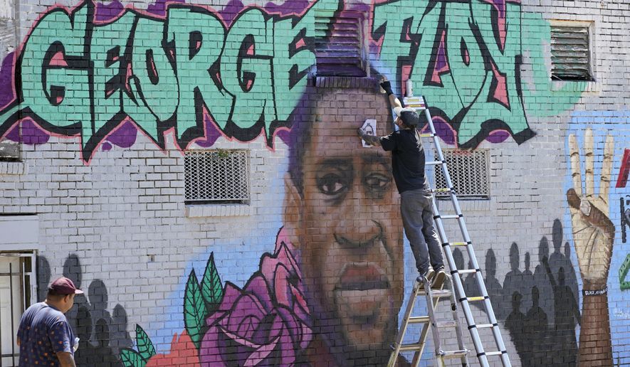 In this file photo from Sunday, June 7, 2020, photo, Zack Murray paints a mural honoring George Floyd, on the side of a building in Houston’s Third Ward. AP Photo/David J. Phillip)