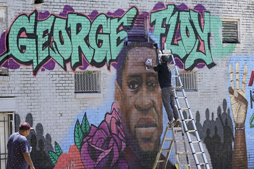 In this file photo from Sunday, June 7, 2020, photo, Zack Murray paints a mural honoring George Floyd, on the side of a building in Houston’s Third Ward. AP Photo/David J. Phillip)