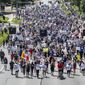 Marchers walk along a street during a rally to remember James Scurlock on Sunday, June 7, 2020, in Omaha, Neb. Scurlock was fatally shot by a white bar owner during an Omaha protest over George Floyd&#x27;s death. (Chris Machian/Omaha World-Herald via AP)