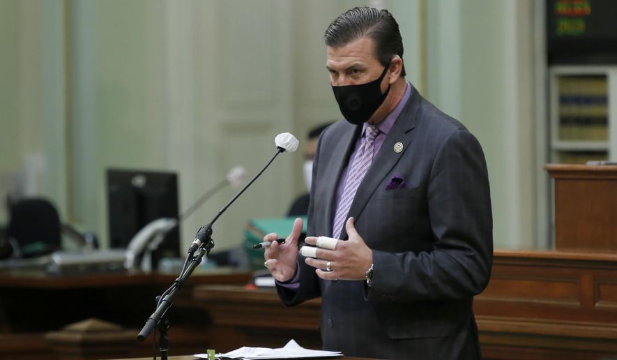 Assemblyman Kevin Mullin, D-South San Francisco, wears a face mask as he urges lawmakers to approve a measure to place a proposed constitutional amendment on the ballot to allow state legislators to vote remotely during emergencies, at the Capitol in Sacramento, Calif., on Wednesday, June 10, 2020. The Assembly approved the measure and it sent it to the Senate which has until June 25 to pass the proposal and place it before voters in November. (AP Photo/Rich Pedroncelli)