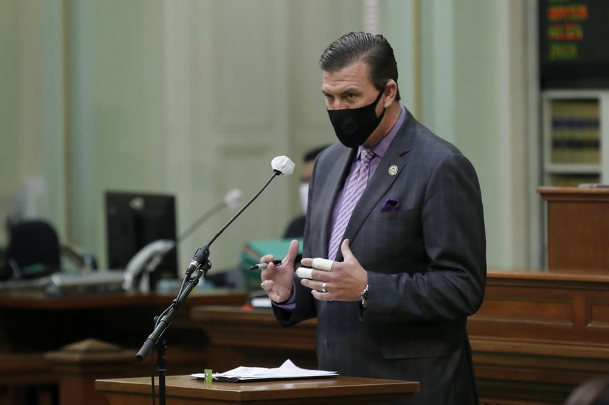 Assemblyman Kevin Mullin, D-South San Francisco, wears a face mask as he urges lawmakers to approve a measure to place a proposed constitutional amendment on the ballot to allow state legislators to vote remotely during emergencies, at the Capitol in Sacramento, Calif., on Wednesday, June 10, 2020. The Assembly approved the measure and it sent it to the Senate which has until June 25 to pass the proposal and place it before voters in November. (AP Photo/Rich Pedroncelli)
