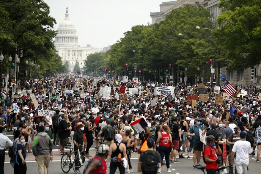 In this June 6, 2020, file photo, demonstrators walk on Pennsylvania Avenue as they protest over the death of George Floyd, a black man who died after being restrained by Minneapolis police officers. A democratic government that is amenable to the changes may enact legislation, or a change of leadership can be forced at the ballot box. (AP Photo/Andrew Harnik, File)