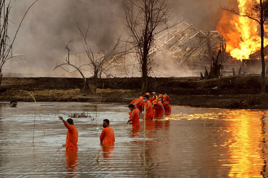 National Disaster Response Force personnel participate in a rescue operation at the site of an oil well that exploded and caught fire at Baghjan, Tinsukia district in the northeastern Indian state of Assam, Wednesday, June 10, 2020. A raging fire at the natural gas field has killed two firefighters and forced nearly 8,000 people to leave their homes, an official said Wednesday. Workers have been trying to cap the well since gas started leaking nearly two weeks ago, said Tridiv Hazarika, a spokesman for government-owned Oil India Limited, which operates the gas field in Baghjan, 550 kilometers (345 miles) east of Gauhati, the Assam state capital. (AP Photo/Partha Sarathi Das)