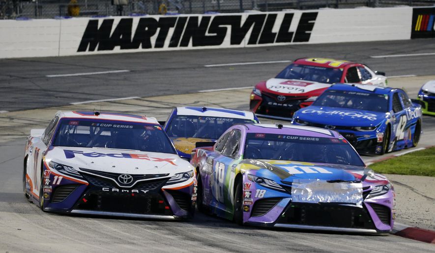 Denny Hamlin (11) and Kyle Busch (18) come through a turn during a NASCAR Cup Series auto race Wednesday, June 10, 2020, in Martinsville, Va. (AP Photo/Steve Helber)