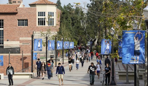 In this Feb. 26, 2015, file photo, students walk on the University of California, Los Angeles campus. A UCLA professor who was suspended following an email exchange with a student who wanted a final exam altered or canceled because of racial unrest, says his refusal to do so has nothing to do with racism. (AP Photo/Damian Dovarganes, File)