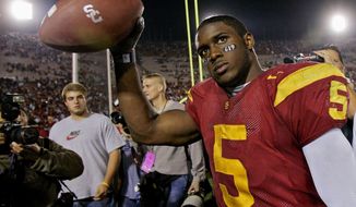 FILE - In this Nov. 19, 2005, file photo, Southern California tail back Reggie Bush walks off the field holding the game ball after the Trojans defeated Fresno State, 50-42, at the Los Angeles Coliseum. The former star running back had been prohibited from interacting in an official capacity with the school he played for from 2003-05 since NCAA sanctions handed down in 2010. Bush and USC were penalized for him and his family receiving impermissible benefits while he was still in school. USC President Carol Folt wrote in a letter to Bush on Wednesday, June 10, 2020, that he could now “be afforded the privileges and courtesies extended to all Trojan football alums.”(AP Photo/Kevork Djansezian, File)