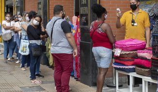 People line up to get their temperatures checked before entering a store in a downtown shopping district of Sao Paulo, Brazil, Wednesday, June 10, 2020. Retail shops reopened on Wednesday in Brazil&#x27;s biggest city after a two-month coronavirus pandemic shutdown that aimed to contain the spread of the new coronavirus. (AP Photo/Andre Penner)