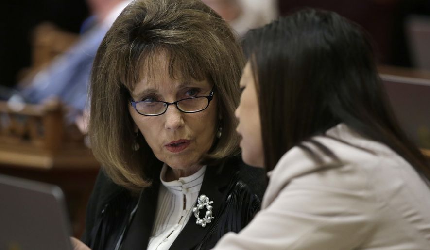 FILE - In this June 14, 2018 file photo, then-Senate Republican Leader Patricia Bates, left, of Laguna Niguel, confers with Sen. Janet Nguyen, R-Fountain Valley, in Sacramento, Calif. Bates joined other Republican state senators on Thursday, June 11, 2020, in opposing a measure that would require counties to send a ballot to every registered voter for the November election. The bill was approved and sent to the Assembly. (AP Photo/Rich Pedroncelli, File)