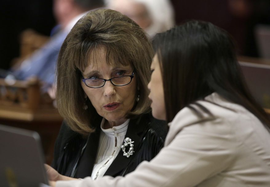 FILE - In this June 14, 2018 file photo, then-Senate Republican Leader Patricia Bates, left, of Laguna Niguel, confers with Sen. Janet Nguyen, R-Fountain Valley, in Sacramento, Calif. Bates joined other Republican state senators on Thursday, June 11, 2020, in opposing a measure that would require counties to send a ballot to every registered voter for the November election. The bill was approved and sent to the Assembly. (AP Photo/Rich Pedroncelli, File)