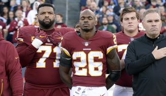In this Dec. 22, 2018, file photo, Washington Redskins running back Adrian Peterson (26) stands for the national anthem before an NFL football game against the Tennessee Titans in Nashville, Tenn. NFL players who want to kneel during the national anthem to protest police brutality and racism have far more support than Colin Kaepernick did  four years ago.  (AP Photo/Mark Zaleski, File) ** FILE **